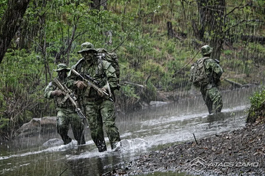A-TACS Camo team fording a river in heavy rain